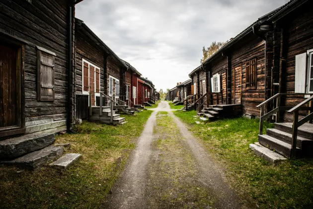 Gamla trähus med grusgång mellan husen.