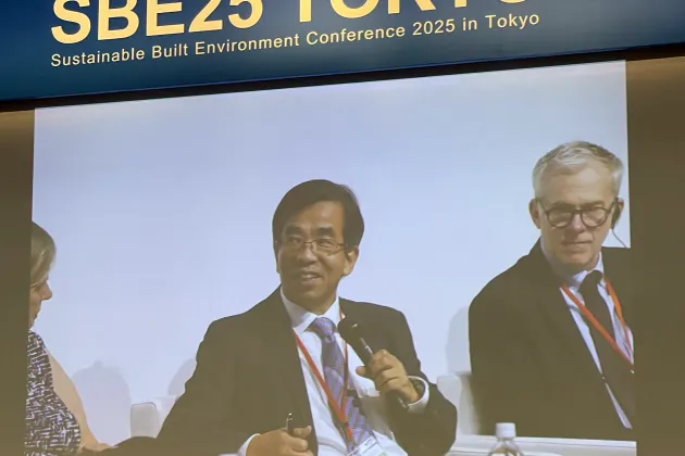 Män i kostym visas på skärm under konferens